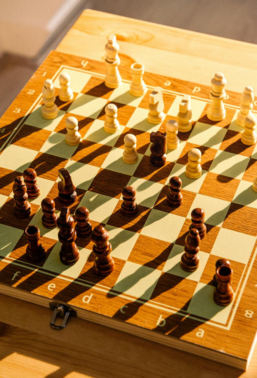 Wooden chess board mid-game in afternoon light